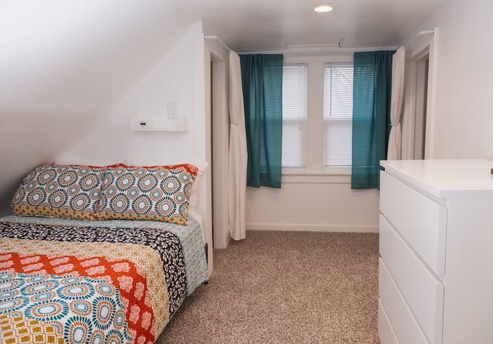 Arriba, dormitorio trasero conectado, cama completa (una cortina separa las dos habitaciones de arriba).