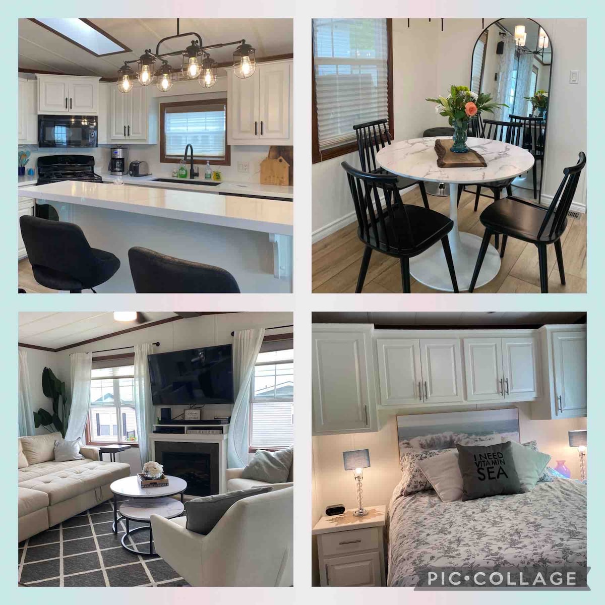 The modern kitchen features white cabinetry, stainless steel appliances, and pendant lighting above a central island with seating. A dining area includes a round marble table surrounded by black chairs, while a cozy living room showcases a sectional sofa, a mounted TV, and light-colored curtains framing a window. A softly decorated bedroom presents a spacious bed with a textured blanket and bedside lamps, enhancing the calming atmosphere.