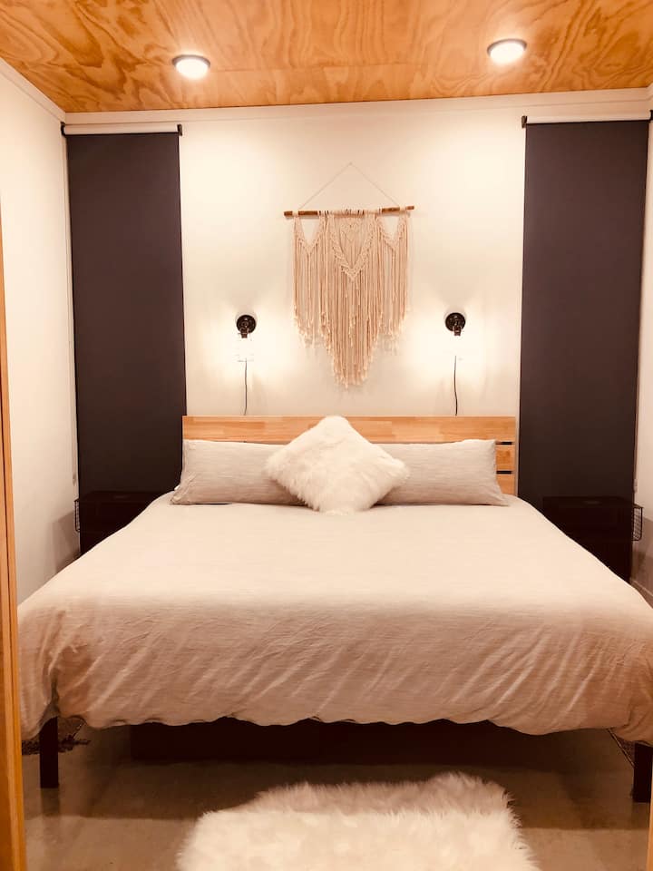 Bedroom has barn doors, king-size bed, and black-out shades