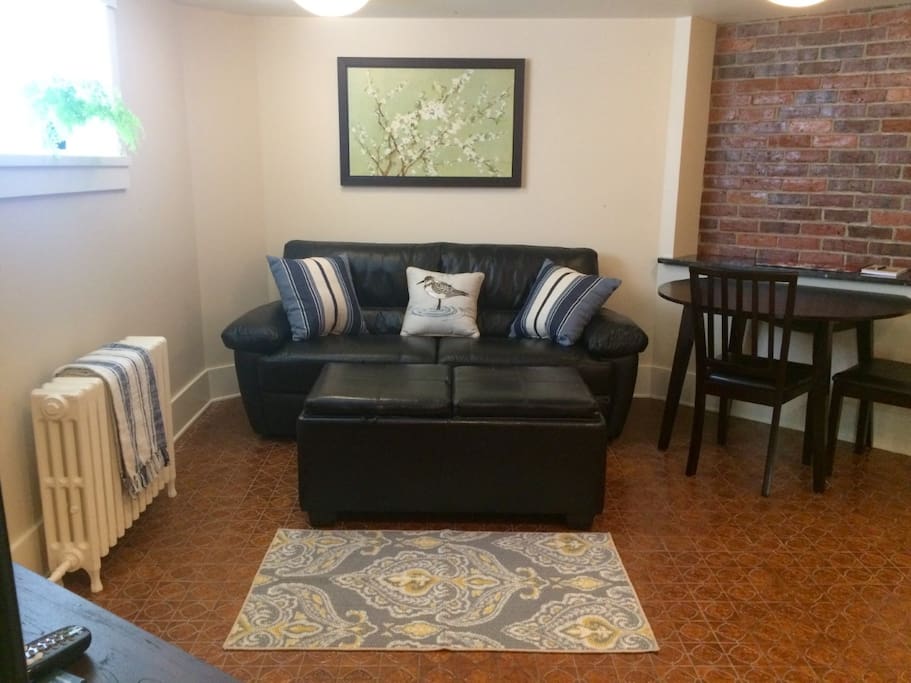 Lounge area with black leather couch where you can sit and relax and watch TV or Netflix