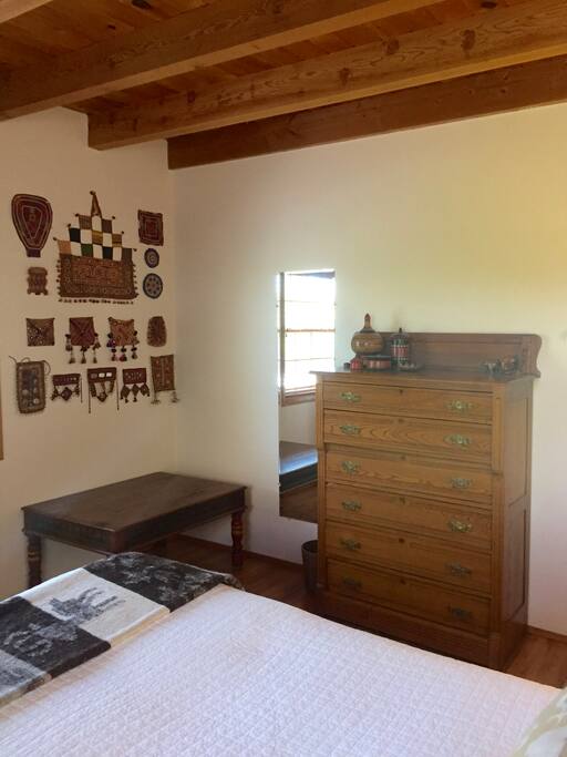 There is a chest of drawers and a large, low table for luggage.