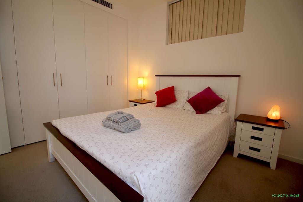 Tranquil queen size bed with plenty of built in wardrobe space