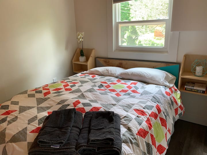 First bedroom with queen bed and vintage lockers for storage. Note: Bedroom walls are loft style and do not extend to the open air vaulted ceiling.