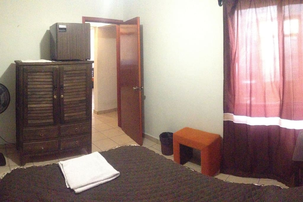 Vista del ventilador, closeth, frigobar y mesa de trabajo