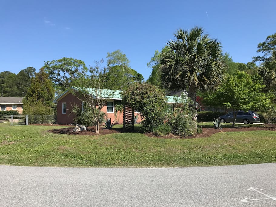 Large corner lot with beautiful greenery & tropical palms.