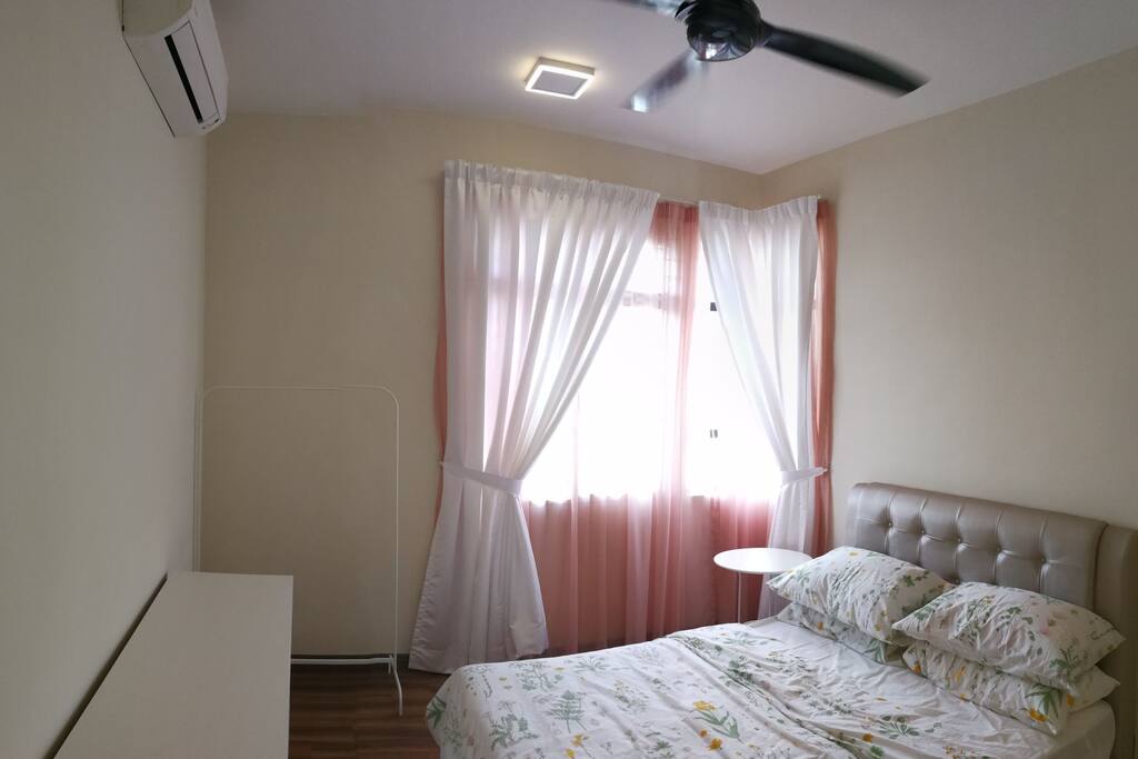 Master bedroom with queen bed, chest of six drawers and a rack to hang ironed clothes