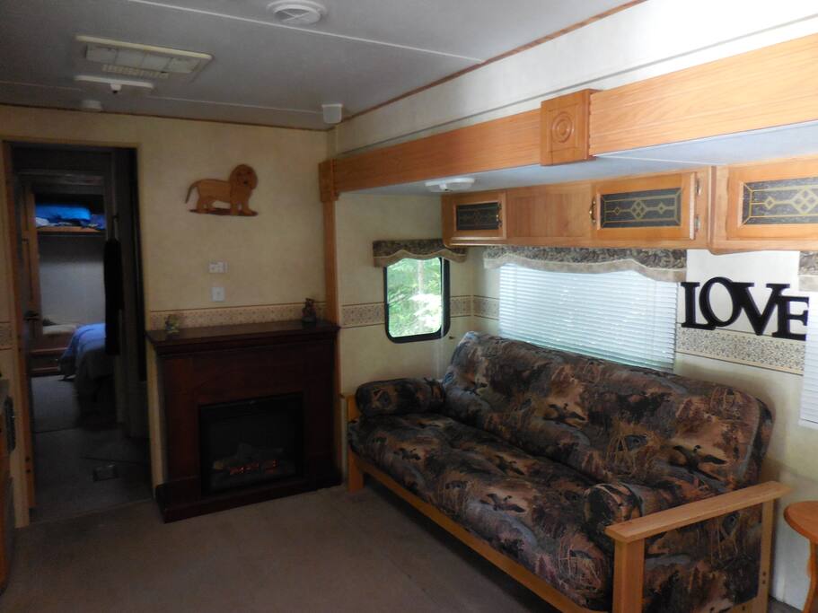Living room with TV and fireplace and a futon that turns into a full size bed