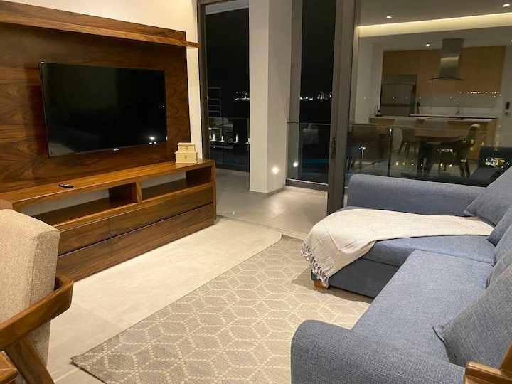 Sebule yenye 55"Televisheni janja yenye kitanda cha sofa na ufikiaji wa mtaro.