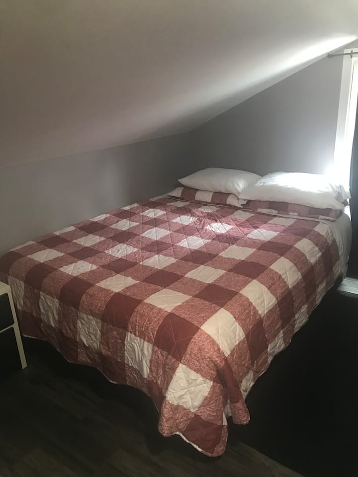 Queen size bed on upper level. Again note the slanted ceiling. 
This is separated by a wall from the living room but no door. 