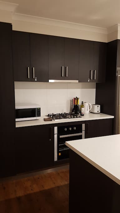 Shared kitchen with microwave, big fridge/freezer, kettle, toaster, pots and pans, dishes and utensils