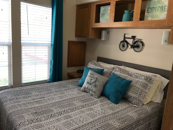 独立卧室，配有标准双人床、遮光窗帘和吊扇。