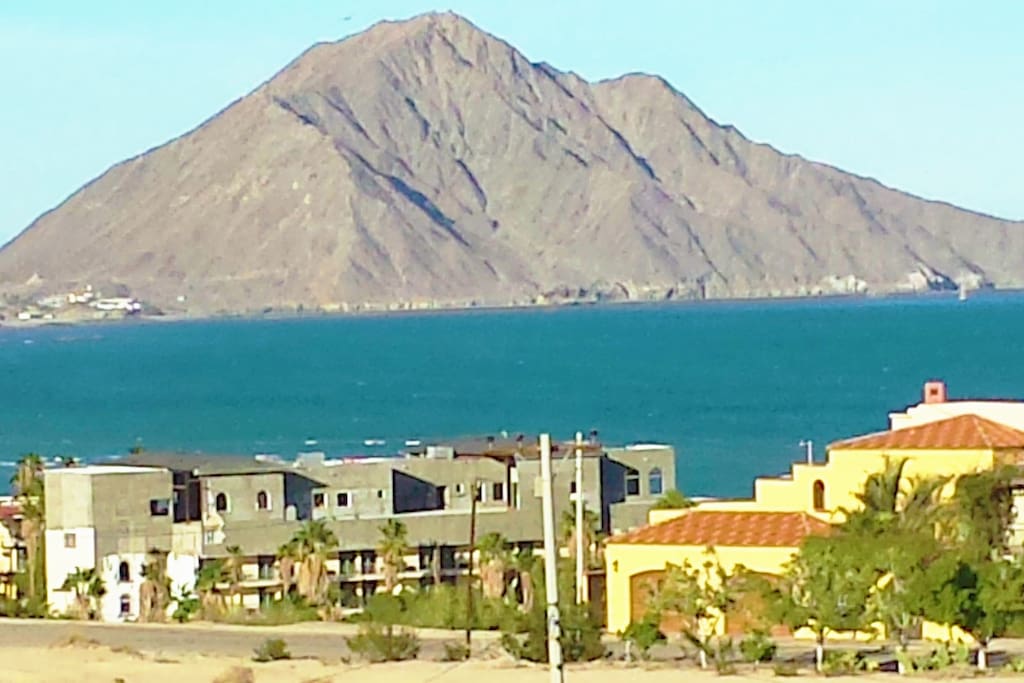 WALK TO THE SEA OF CORTEZ AND THE MARINA from this 2 BR fully furnished, spacious 1100 sq. ft. home, just 2 miles south of downtown where you will find finer beaches, tranquil setting with a panorama of Sea and Mountain Views, with balcony and deck to enjoy rejuvenating sea breeze and country air, with Wifi, Cable TV, Airconditioning, Hot Water, Modern Conveniences -All at our special low prices with no added resort fees.