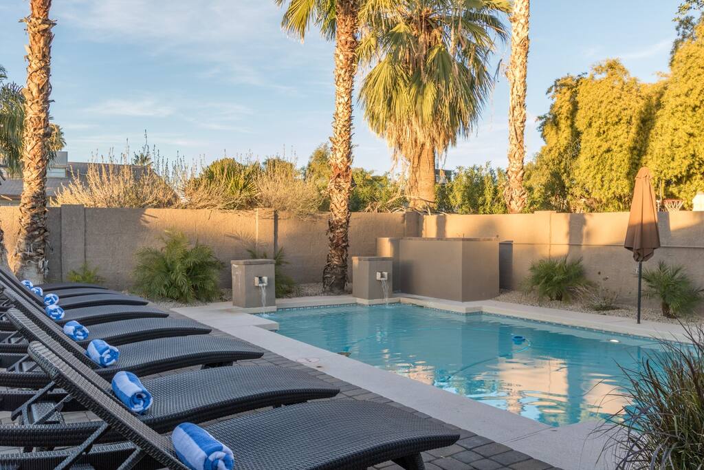 Large Pool With Waterfalls and Poolside Loungers