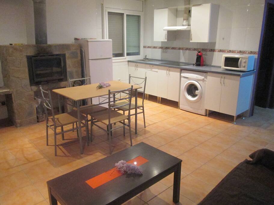 Comedor con cocina y la chimenea.