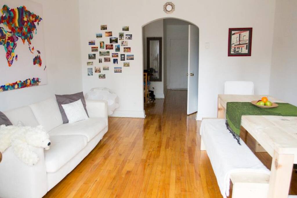 The living room from a different angle. Soft morning light coming in. The couch can comfortably accommodate a solo traveler, and the space in between the table and sofa is large enough for a double mattress (provided if needed).