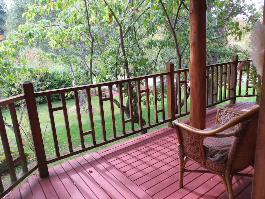 Deck with wicker chairs overlooking yard.