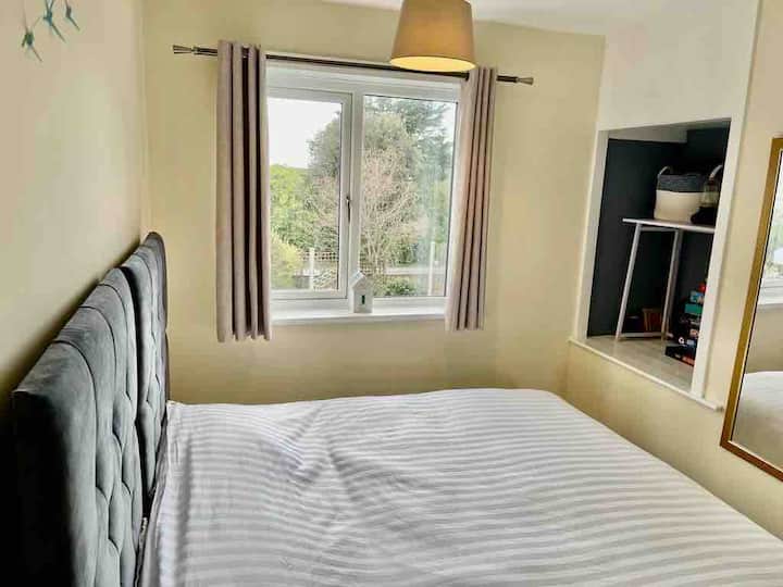 Mwonekano wa bahari kupitia miti, dirisha la chumba cha kulala cha pili linaangalia nje kwenye roshani.