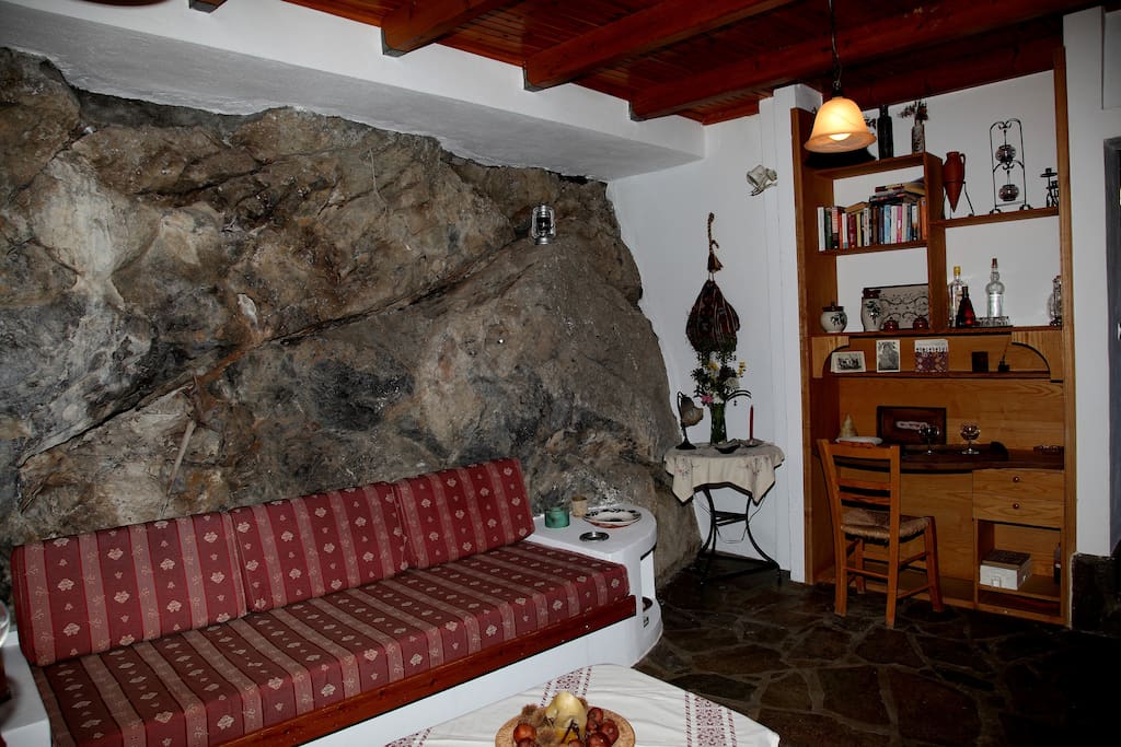 The sofa, in front of the rock.