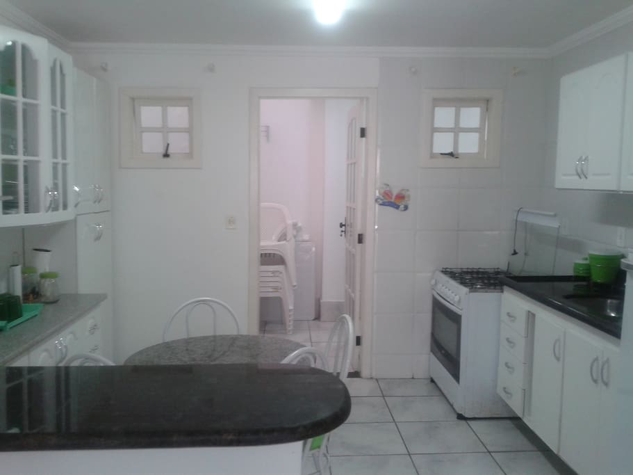 Cozinha americana, equipada com geladeira duplex, fogão, louças e panelas diversas, microondas, bebedouro, torradeira, temos churrasqueira móvel, cadeiras e mesas móveis