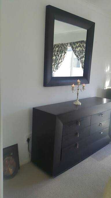 Close view of a solid wood dressing table which matches the headboard.
