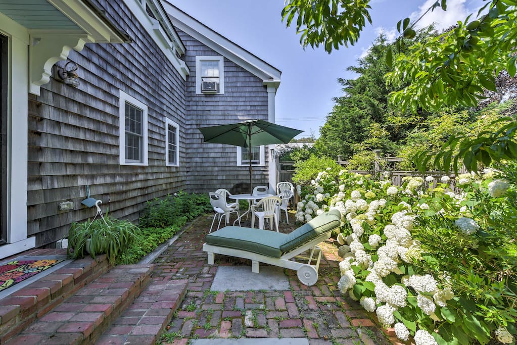 An attractive yard features outdoor furnishings, gas grill, and an outdoor shower!