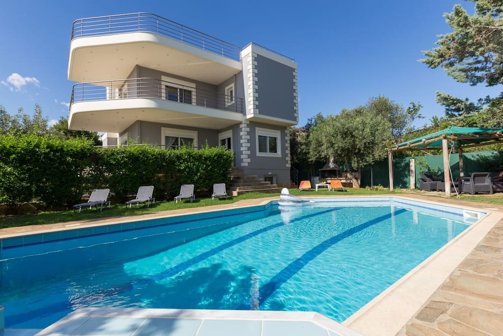 Villa with a pool , sunbeds and outdoor sitting areas