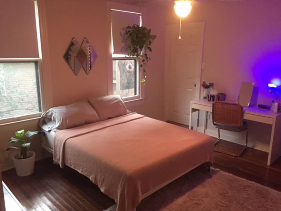 Open bedroom with a comfortable queen-sized bed and desk space.