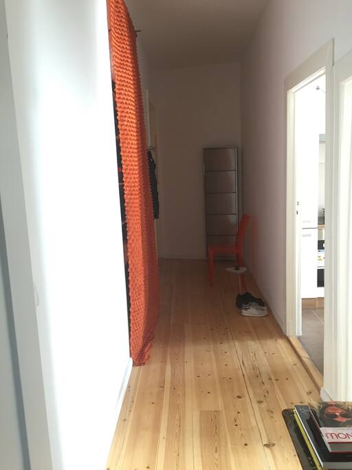 Long corridor with closet, storage, chair, table and hall stand.