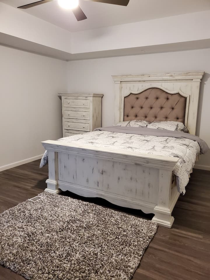 Cama tamaño king con cofre para tus paños y artículos en el primer dormitorio.