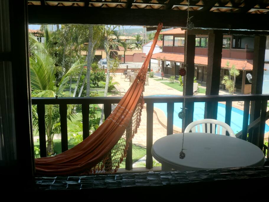 Vista da varanda, com rede e mesa para 4 pessoas.