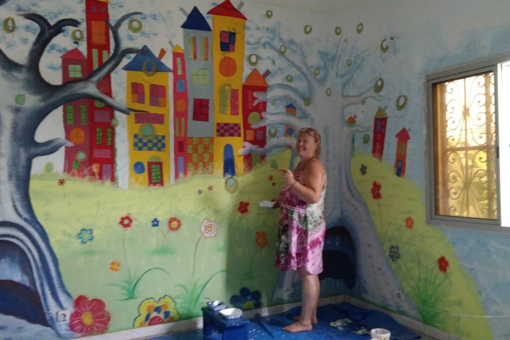 en cours de peinture dans la chambre caméléon, avec un paysage pop art inspiré de Hunderwasser et de l'exposition que j'ai vu avec ma fille a l'atelier des lumières à Paris sur Klimt et Hunderwasser...je n'ai pu résister ! avec le coté sénégalais avec les baobabs en premier plan !
