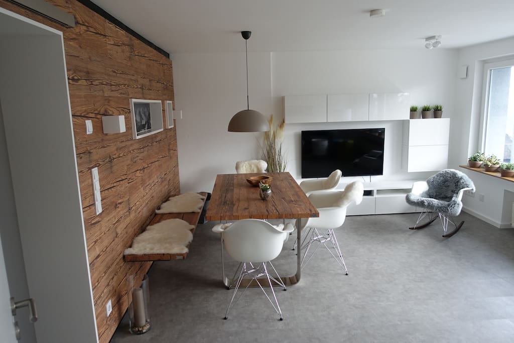 Wohnzimmer mit Naturholzsitzbank, 4 Stühlen und Schaukelstuhl