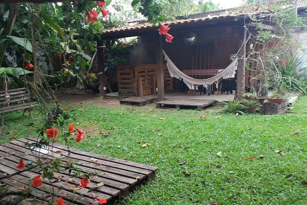 Jardim dos fundos com área para churrasco.