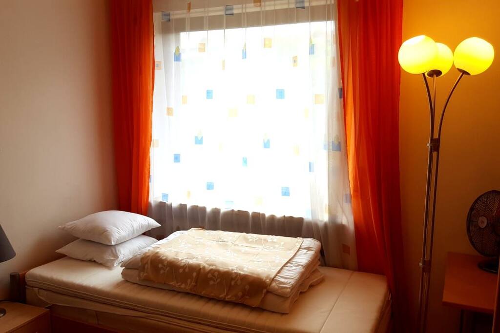 Einzelbett mit mehr als genügend Decken und Kissen