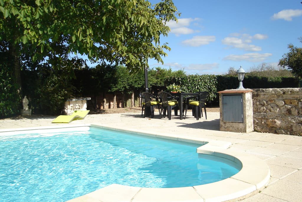 pool and seating area including sun chairs and tables