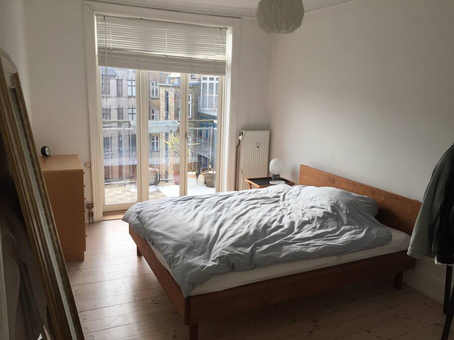 Large, bright bedroom with king size bed and exit to balcony