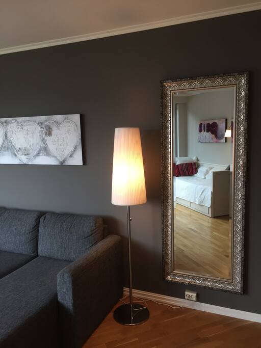 Sovesofa og brisk (i speilbildet) i stuen