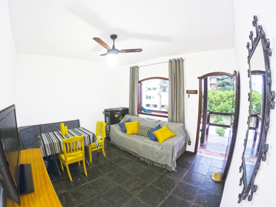 Sala de estar com sofá, saída para a varanda com rede e freezer para bebidas geladas /
Sofa in living room, exit to balcony with hammock and fridge for cold drinks.