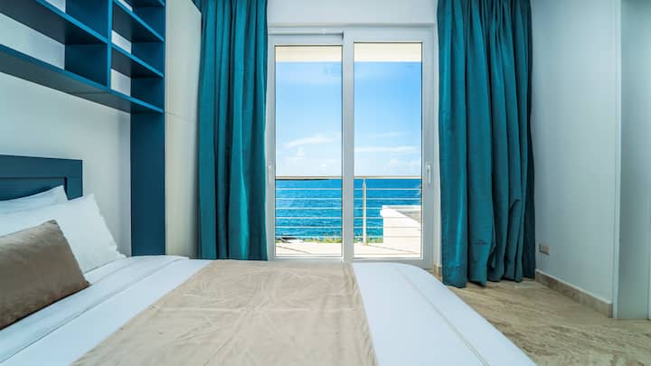 Dormitorio con cama doble, baño privado con ducha, aire acondicionado, TV y caja fuerte, balcón e impresionantes vistas.