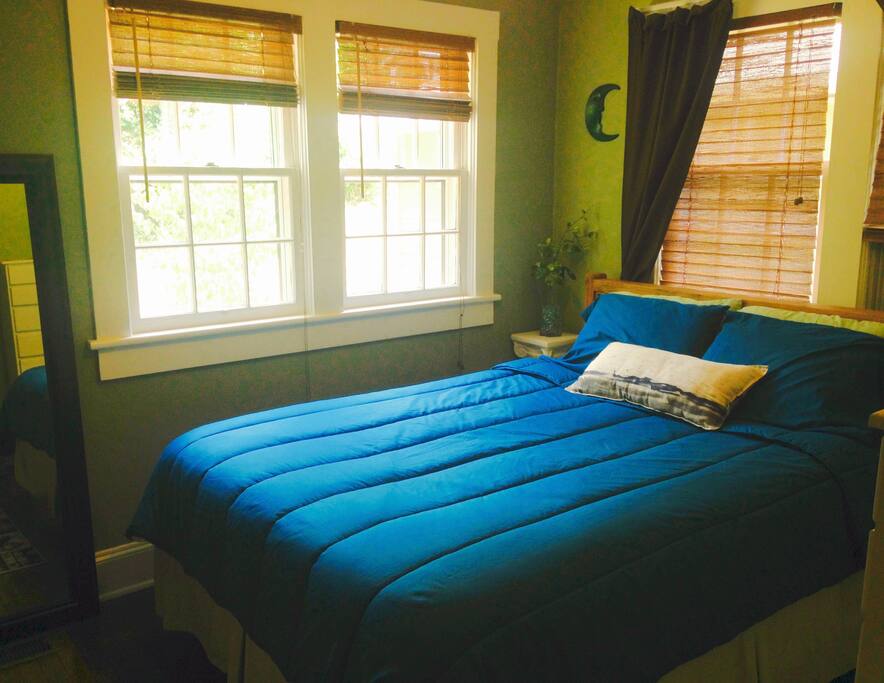 Bedroom with queen size bed, tv, dresser and closet.