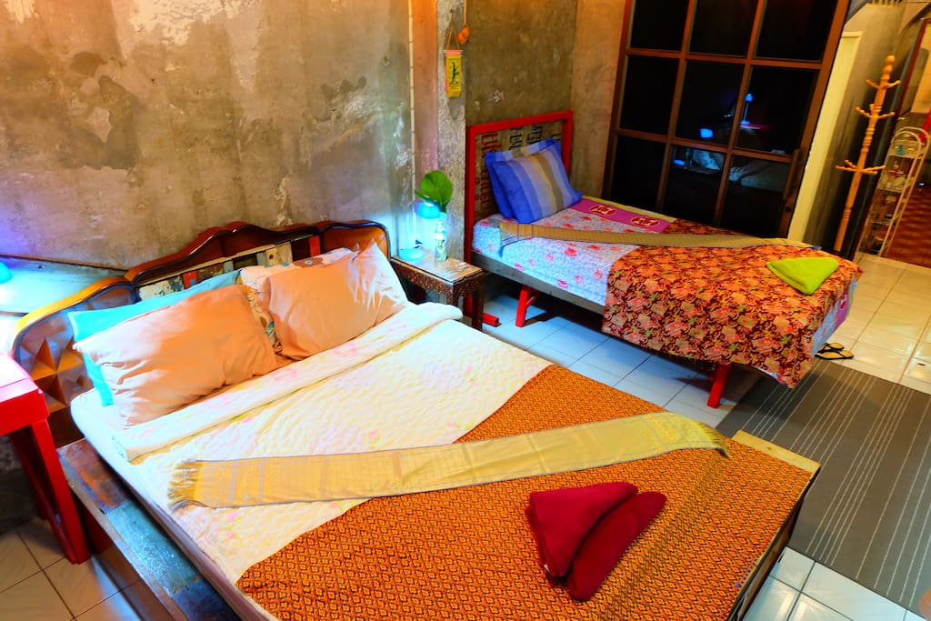Art Deco 1920's vintage queen bed & colored soft lighting.A 12' wall of Thai teak windows