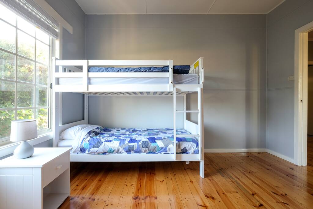 The second bedroom features a bunk bed, tallboy and wardrobes