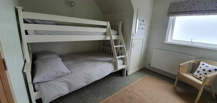 Bunk room with a double bed on the bottom and a single on top. Amazing views down to beach.