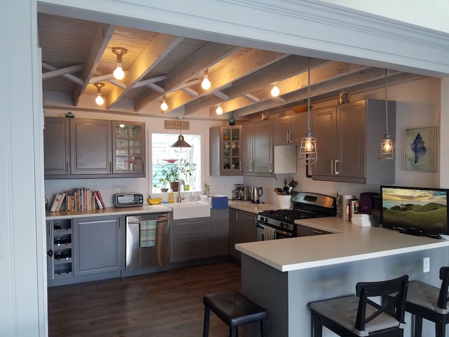 Kitchen from dining area with exposed ceiling & custom light fixtures