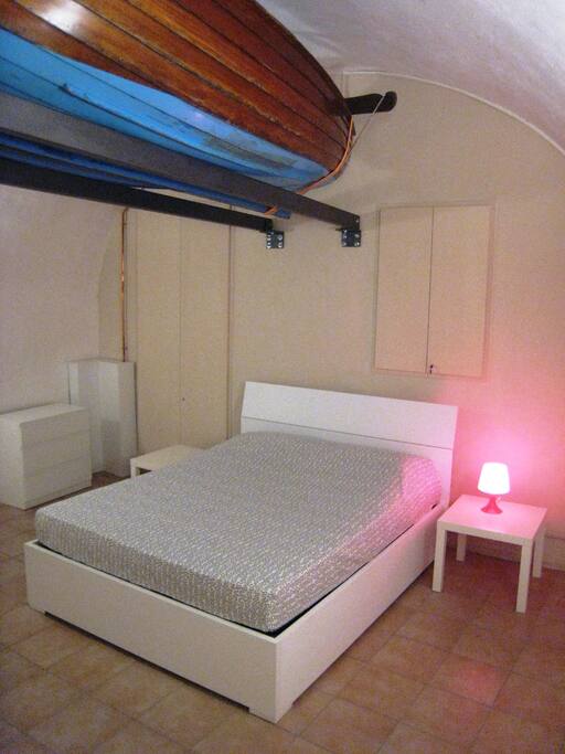 Bedroom with queen-size bed set to the rear of the apartment was the original boat storage and repair workshop for the monastery