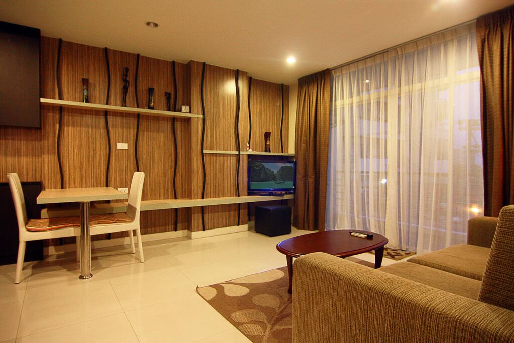 Big living room with sofa, TV, and balcony access
