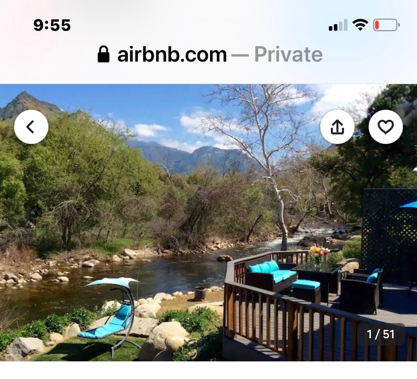 A tranquil outdoor area features a deck overlooking the flowing Kaweah River, complemented by bright blue seating arrangements. Natural greenery and distant mountains are visible in the background, enhancing the serene setting.