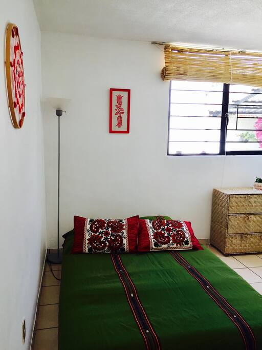 Habitación privada con cajonera y otros muebles para tus pertenencias y decoración artesanal.