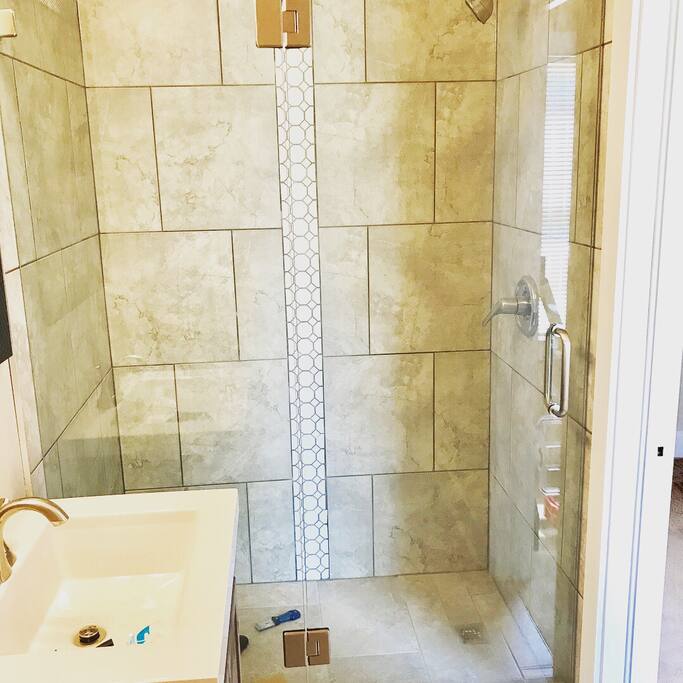 Spacious, custom tiled walk in shower and glass door