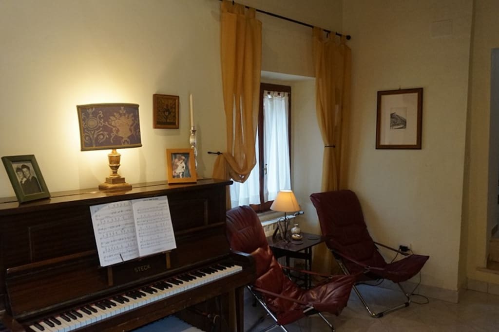 Living Room, Piano 2 chairs and circular coffee table.